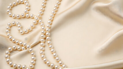 Elegant pearls on soft beige fabric background.