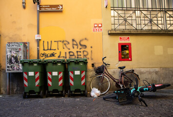 Urban decay in Parma city center, alley full of trash bags, waste, poor street cleanliness, signs of neglect