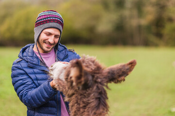 volunteer for animal rights activist taking care of a rescued donkey in a farm sanctuary 