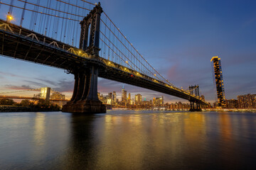 The Manhattan Bridge in New York at dusk with the Brooklyn  Bridge in the back