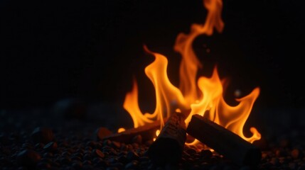 Fototapeta premium Warm embers glowing in the darkness, a small fire burning brightly on a bed of pebbles