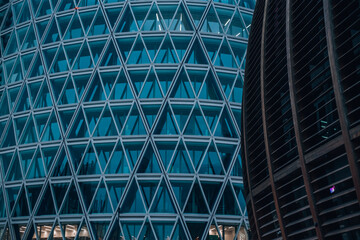 Geometric Facade: A close-up shot of a modern glass and steel skyscraper with a mesmerizing...