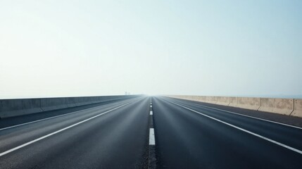 Asphalt Road Stretching to a Hazy Horizon with Concrete Barriers