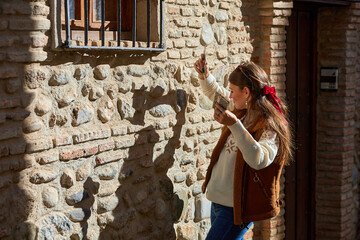 A woman with long hair tied with a red ribbon holds tarot cards in one hand and gestures with the...