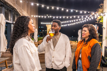 Happy friends talking drinking beer at roof of a bar