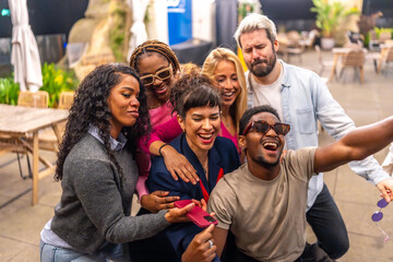 Happy group of multiracial friends taking selfie at night party