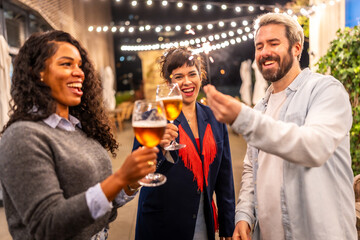 Friends toasting and holding sparklers while enjoying a night party