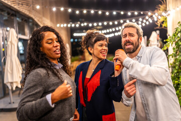Man singing karaoke at terrace of bar during night party
