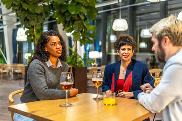 Multiracial friends taking drinking beer in a night bar terrace