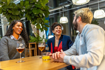 Friends laughing while talking in a night bar terrace