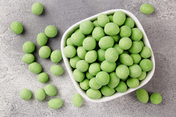 Spicy coated fried peanuts on gray background. Snacks and nuts.