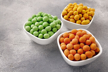 Spicy coated fried peanuts on gray background. Snacks and nuts.