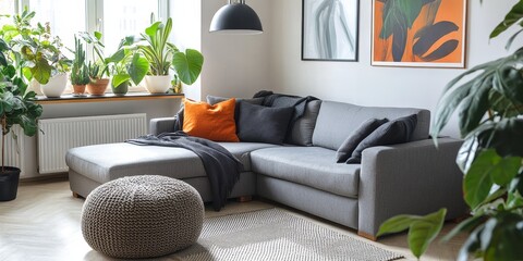 Stylish grey corner couch adorned with cushions showcased in an elegant white living room interior, featuring a window, vibrant plants, a cozy carpet, and an oversized lamp for a welcoming vibe.
