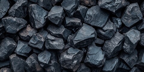 Large pieces of black coal arranged in a pile create a striking background. The texture of the black coal adds depth and character to the visual, making it an impactful image of black coal.