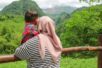 Happy cheerful Asian muslim family living together in a weekend, woman muslim embracing her lovely...