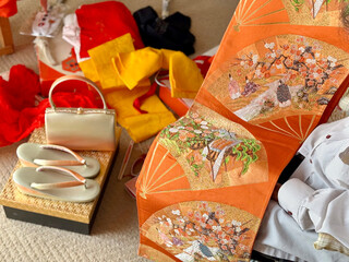 着物の小物と帯を広げて見る女性