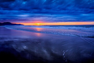 Dramatic Ocean Sunset with Dark Clouds and Reflective Shoreline, Pantai Dalit Beach, Sabah, Malaysia