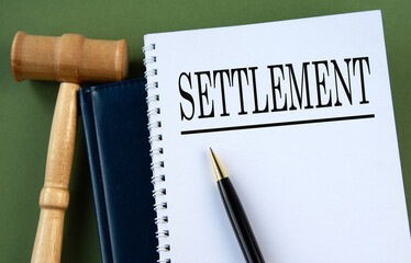 SETTLEMENT - word on a white sheet with a judge's gavel