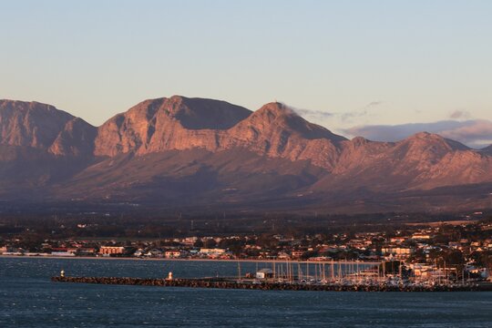 : "Scenic View of Gordon's Bay with Majestic Mountains at Sunset in Cape Town, South Africa