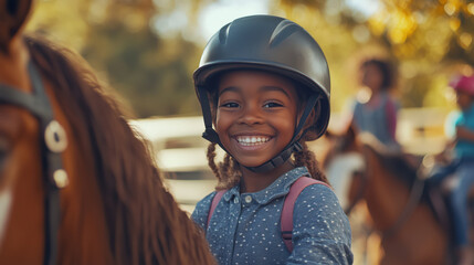 Girl in protective helmet smiling, learning to ride a pony or horse.