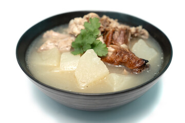 Stewed radish with roasted duck bones on isolate white background, Close up.