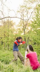 Woman filming friend dancing outdoors in nature