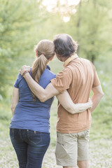 Senior couple embracing while hiking in lush green park, madrid