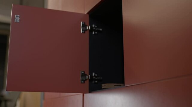 Young woman with fiery curls takes bag from small locker then places back. Moment of everyday routine unfolds. Piece of ordinary life