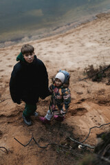 Brothers and sisters play on the river bank in the winter forest