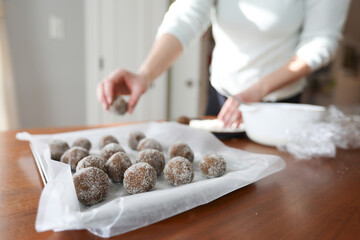 Woman placing gingerbread cookie dough on baking sheet