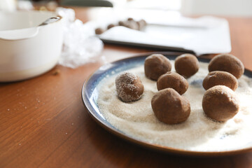 Gingerbread cookie dough sitting in plate of sugar for coating