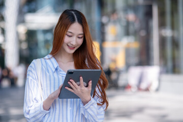 Woman with long red hair is holding a tablet