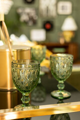 Vintage green glass goblets on an elegant reflective surface.