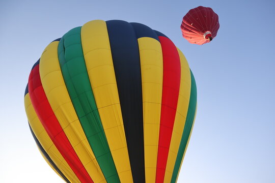 Colorful hot air balloon preparing for liftoff under a clear sky.