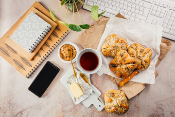 Lunch in a office, delicious bread rolls with butter and coffee on desktopffee