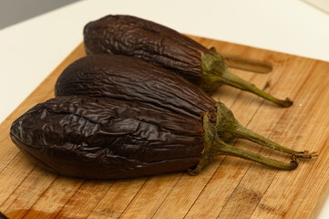 Freshly harvested eggplants on a wooden cutting board ready for culinary creations