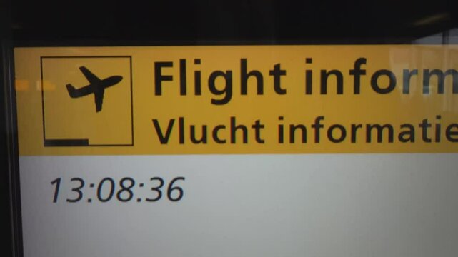Amsterdam, Netherlands A flight information display at Schiphol Airport in Dutch and English with digital time. 