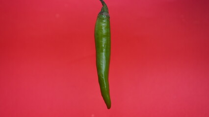 green chili pepper isolated on a red background