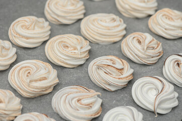 Delightful swirls of meringue cookies cooling on a countertop after being freshly baked in a cozy...