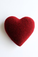 Obraz premium Red knitted heart on white background symbolizing warmth in love