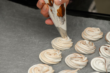 Creating delicate meringue swirls in a cozy kitchen setting during a baking session