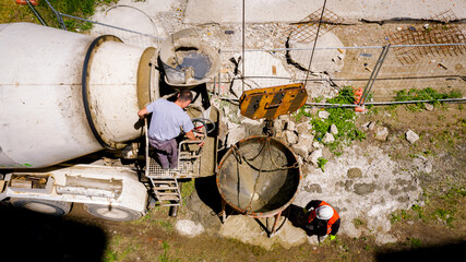 Aerial view on worker as washing ramp of concrete mixer