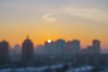 Naklejka premium blurred picture of a sunrise panorama in a city, an urban landscape, the morning sky over city roofs, the first rays of the sun