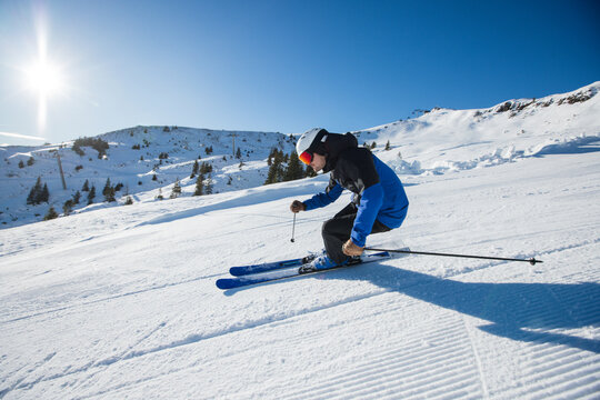 Dynamic skier gliding down sunny slopes in the Austrian Alps