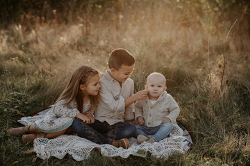 Older siblings, brother and sister, attend to their young baby brother