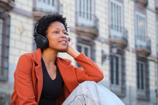 Young woman enjoying music with headphones in the city