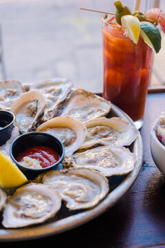 Fresh raw oysters on ice with lemon and a loaded Bloody Mary.