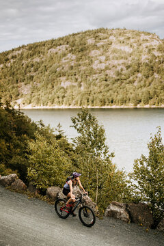 female mountain biker on carraige road, Acadia, Maine