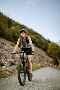 Smiling woman rides bike on carriage road, Bar Harbor, maine