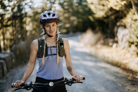 Smiling young female mountain biker wearing helmet, Maine